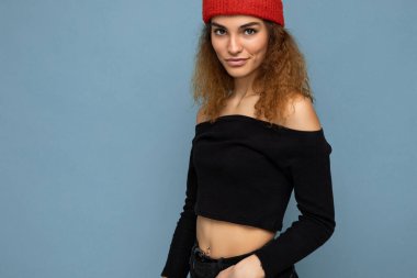 Çekici, gülümseyen, mutlu, esmer, sarışın bir kadın. Renkli arka plan duvarının üzerinde izole bir şekilde duruyor. Günlük şık kıyafetler giyiyor ve kameraya bakarken yüz ifadelerini gösteriyor.