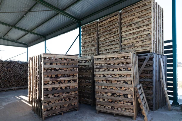 Natürlicher Holzhintergrund aus gehacktem Brennholz in Holzkisten in einer Lagerhalle auf der Straße. Brennholz gestapelt und für den Winter vorbereitet — Stockfoto