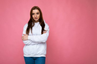 Kendine güveni tam esmer, samimi duyguları olan, arka planda fotokopi odası olan, şık, açık renk kapüşonlu bir kadın kameraya bakıyor.