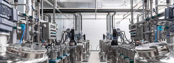 Foto panorâmica de tubos de metal cinza e tanques. Química e produção de medicamentos. Fábrica farmacêutica. Interior de uma fábrica de alta tecnologia, produção moderna — Fotografia de Stock