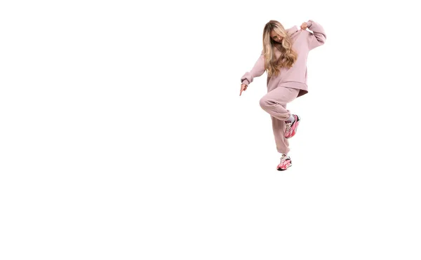 Chica en un traje deportivo rosa saltando sobre un fondo blanco — Foto de Stock