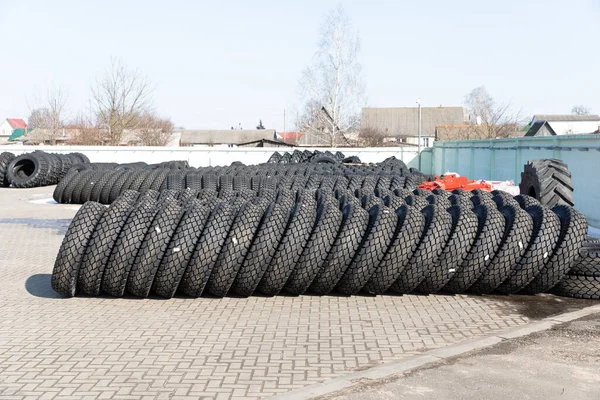 Foto de neumáticos grandes negros sobre ruedas para coches grandes que yacen sobre asfalto gris en la calle — Foto de Stock