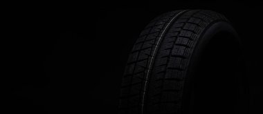 Siyah bir arkaplanda siyah bir lastiğin resmi