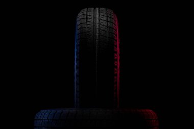 Kışın siyah arka planda araba sürmek için lastik izleri var.