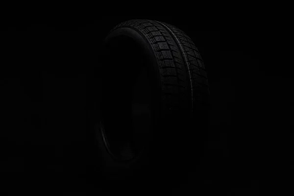 Černá pneumatika na černém pozadí — Stock fotografie