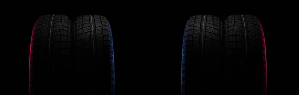 Dois pneus pretos em um fundo preto com uma banda de rodagem para dirigir na neve — Fotografia de Stock