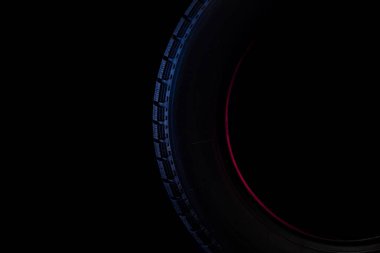 Siyah zemin üzerinde kış yürüyüşü olan bir lastiğin resmi.