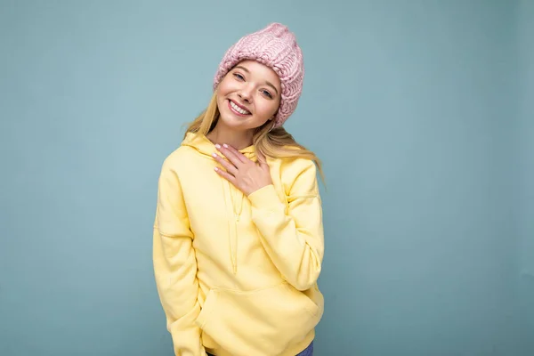 Aantrekkelijke glimlachende vrolijke jonge blonde vrouw geïsoleerd over kleurrijke achtergrond muur dragen dagelijks stijlvolle outfit tonen gezicht emoties kijken naar camera — Stockfoto