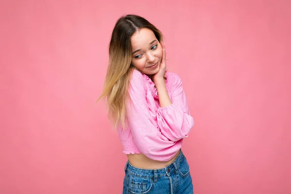 Foto shot van jong mooi schattig gelukkig blond vrouw dragen stijlvolle roze gewas top geïsoleerd over roze achtergrond met kopieerruimte — Stockfoto