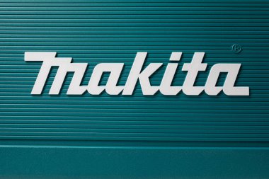 Yeşil arka planda beyaz Makita kelimesinin fotoğrafı. Yapı araçları ayarlandı