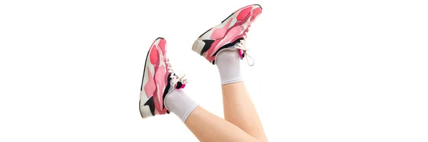 Foto de pernas femininas em tênis rosa em um fundo branco — Fotografia de Stock