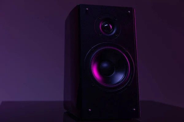Musik högtalare från hemmabio på mörk bakgrund med lila bakgrundsbelysning, musikbranschen proffs koncept — Stockfoto