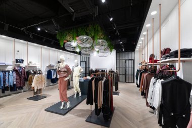 Bir gençlik mağazasının fotoğrafı, kotlu, dış giyimli, ceketli, gömlekli, kazaklı, şapkalı, tişörtlü, kapüşonlu, pantalonlu, alışveriş merkezindeki erkekler ve kadınlar için