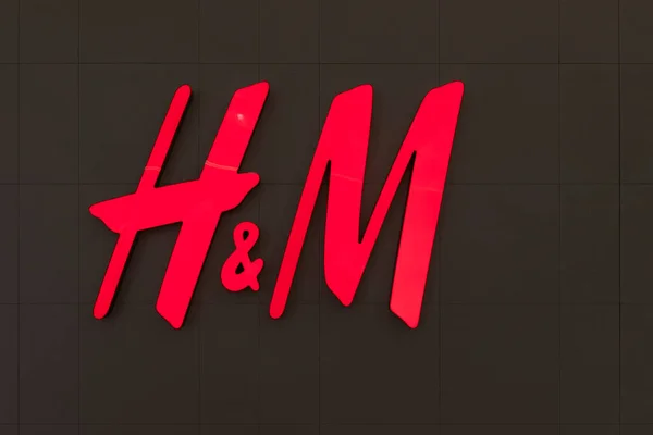 Minsk, Bielorrusia - 25 de noviembre de 2021: Foto del logotipo de una marca de ropa para toda la familia. Letras rojas H y M sobre fondo negro con espacio de copia — Foto de Stock