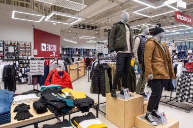 Minsk, Belarus - 25 Kasım 2021: Bir alışveriş merkezindeki erkek ve kadınlar için elbise, kot pantolon, dış giyim, ceket, tişört, kazak, kapüşon, pantolon, gömlek