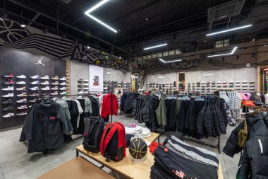 Minsk, Belarus - 25 Kasım 2021: Bir alışveriş merkezindeki erkek ve kadınlar için kot pantolon, dış giyim, ceket, ayakkabı, spor ayakkabı, tişört, kapüşon, pantalon