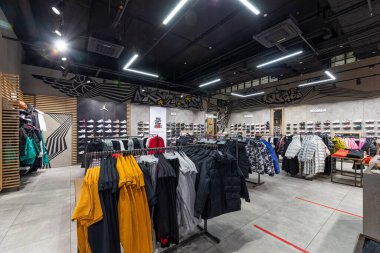 Minsk, Belarus - 25 Kasım 2021: Bir alışveriş merkezindeki erkek ve kadınlar için kot pantolon, dış giyim, ceket, ayakkabı, spor ayakkabı, tişört, kapüşon, pantalon