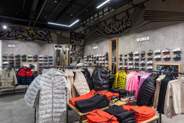 Minsk, Belarus - 25 Kasım 2021: Bir alışveriş merkezindeki erkek ve kadınlar için kot pantolon, dış giyim, ceket, ayakkabı, spor ayakkabı, tişört, kapüşon, pantalon