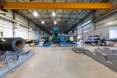 Metal levha profil oluşturma makinesi, çatı için çelik döşeme işlemi, endüstriyel üretim. Bitki ve fabrikanın arka planı