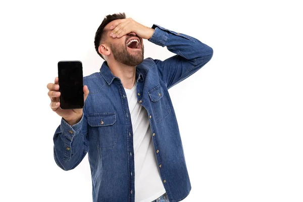 Veselý radostný muž předvádí obrazovku telefonu se štěstím zakrývající si tvář rukou — Stock fotografie