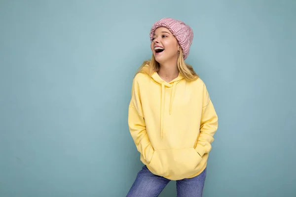 Charming joyful positive happy young blonde woman isolated over colourful background wall wearing casual stylish clothes feeling sincere emotions looking to the side — 图库照片