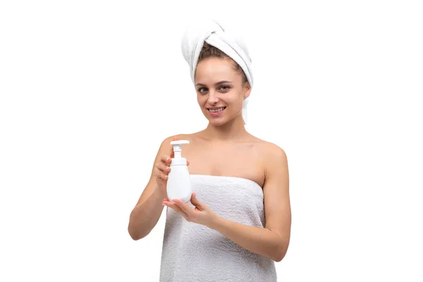 Middle-aged woman holding a bottle of white soap in her hands — Stock Photo, Image