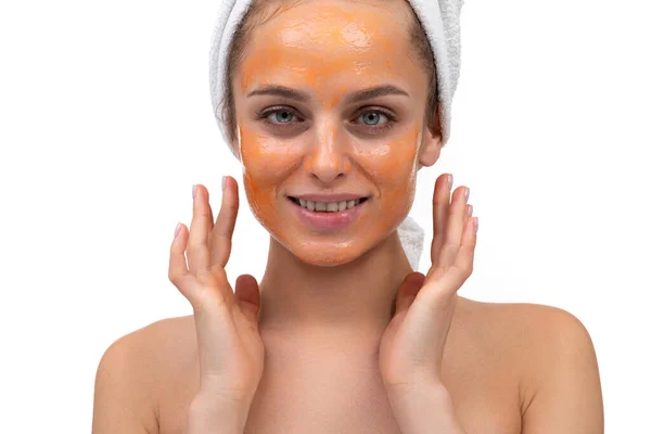 Bela mulher após o chuveiro com máscara cosmética laranja em seu rosto — Fotografia de Stock