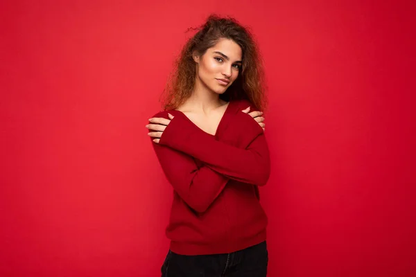 섹시하고 아름다운 곱슬곱슬 한 젊은 여성 이 어렴풋이 어두운 붉은 스웨터를 입은 채 배경 벽에 고립된 진실 한 감정을 가지고 있다. 긍정적 인 개념 — 스톡 사진