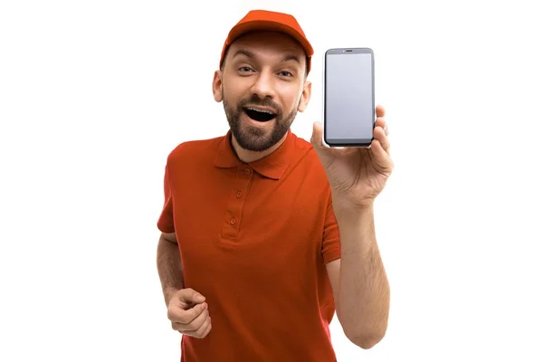 Emotional charismatic couriers in red uniforms demonstrate an application on a smartphone screen — Stock Photo, Image