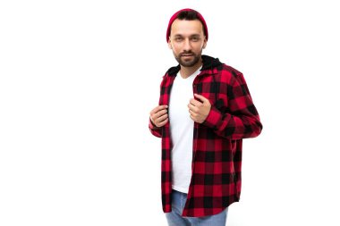 Beyaz tişörtlü, beyaz arka planda siyah kafesli genç bir adam.