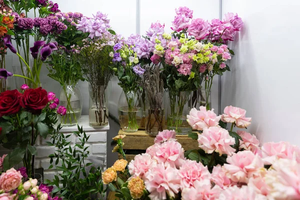 Vasos com rosas frescas cortadas na florista — Fotografia de Stock