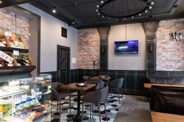 Minsk, Belarus - 20 Aralık 2021: Vitrin dolabı ve ziyaretçiler için masaları olan küçük bir kafe.