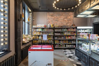 Minsk, Belarus - 20 Aralık 2021: Koridorun ortasında buzdolabı olan rahat bir marketin içi