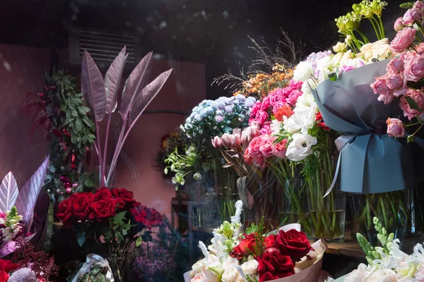 Luxurious bouquets on the shelves in the refrigerator cabinet of the florist salon, a photo of the showcase through the glass — Fotografia de Stock