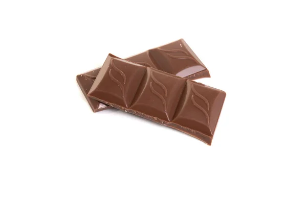 Stukjes melkchocolade op witte geïsoleerde achtergrond — Stockfoto