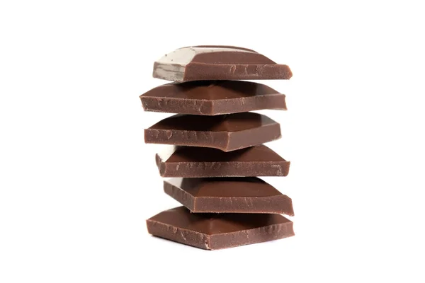 Melk chocolade plakjes gestapelde piramide op elkaar op witte geïsoleerde achtergrond — Stockfoto