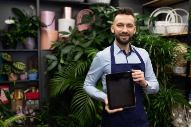 Çiçekçi buketlerde ve saksı bitkilerinde tablet ekranı gösteriyor