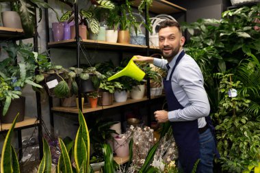 Çiçekleri sulayan çiçekçi.