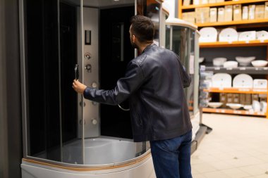 a buyer in a hardware store examines a shower cubicle well