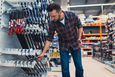 İnşaat hipermarketinde bir alıcı bir çivi sökücü seçer.