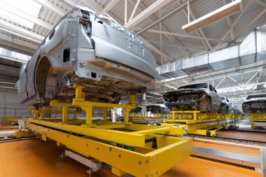 Araba cesetleri montaj hattında. Araba üretim fabrikası. Modern otomotiv endüstrisi. Yüksek teknoloji ürünü bir şirkette boyanmadan önce kontrol edilen bir araba.