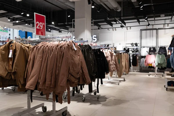 Interiér obchodu se stylově levným oblečením, bundy na ramínkách v širokém sortimentu — Stock fotografie