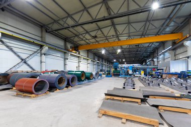 Metal levha profil oluşturma makinesi, çatı için çelik döşeme işlemi, endüstriyel üretim. Bitki ve fabrikanın arka planı