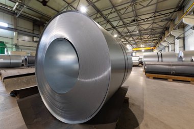 Metalik makine üretim hattının çatısındaki metal fayansların yakından çekilmiş fotoğrafı. Fabrikada soğuk çelik bobinler var.