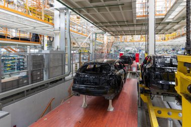 Araba cesetleri montaj hattında. Araba üretim fabrikası. Modern otomotiv endüstrisi. Yüksek teknoloji ürünü bir şirkette boyanmadan önce kontrol edilen bir araba.