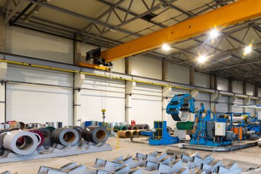 Metal levha profil oluşturma makinesi, çatı için çelik döşeme işlemi, endüstriyel üretim. Bitki ve fabrikanın arka planı