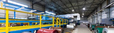 Fabrikadaki kesme makinesinde, demir fabrikasında ve metal fabrikasında galvanize çelik levha rulosunun panoramik fotoğraf çekimi. Bitki konsepti