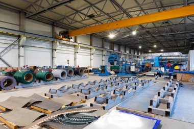 Metal levha profil oluşturma makinesi, çatı için çelik döşeme işlemi, endüstriyel üretim. Bitki ve fabrikanın arka planı