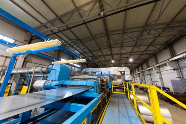 Çatı için metal fayans üretim hattı. Metal fabrikası atölyesinde çelik oluşturma makinesi. Metal levha profilleme makinesi