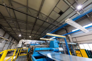 Çatı için metal fayans üretim hattı. Metal fabrikası atölyesinde çelik oluşturma makinesi. Metal levha profilleme makinesi